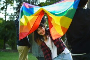 Young girl activist with pride rainbow flag.