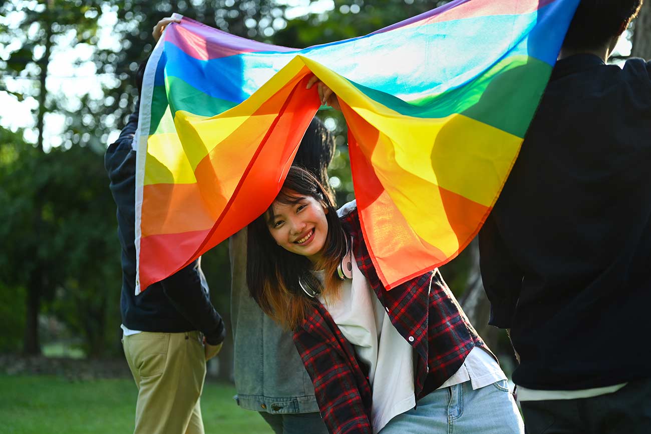 Young girl activist with pride rainbow flag.