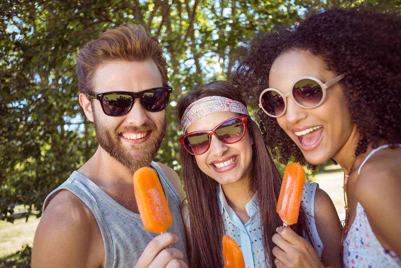 Hipster friends enjoying ice lollies on a summers day.