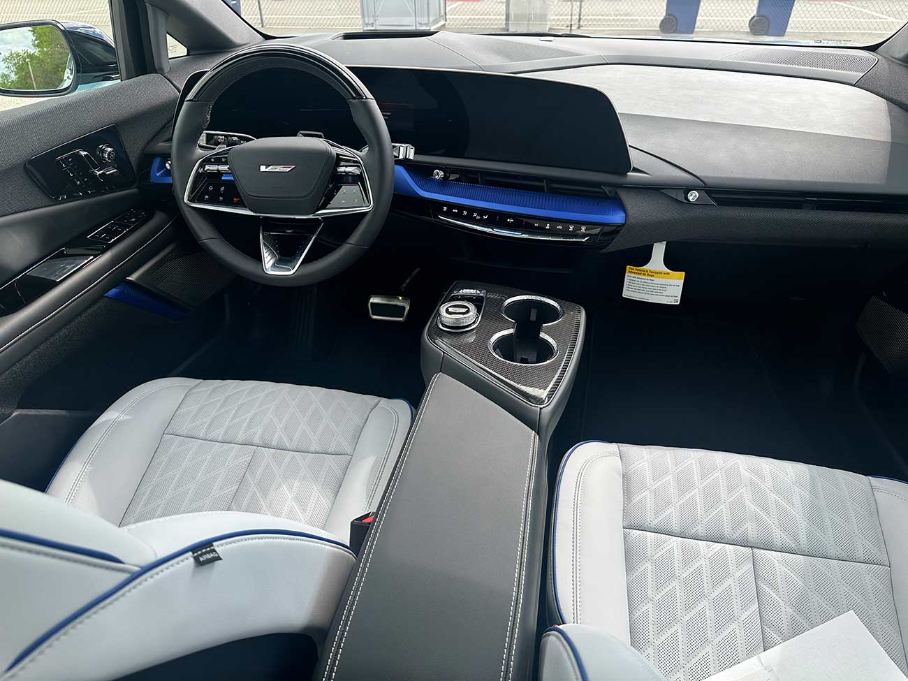 Interior steering wheel and dash console of the 2026 Cadillac Optiq-V.