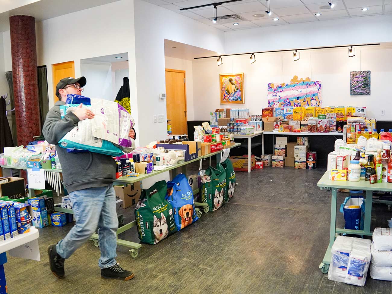 Andi carrying dog or cat food donations to stock the tables.