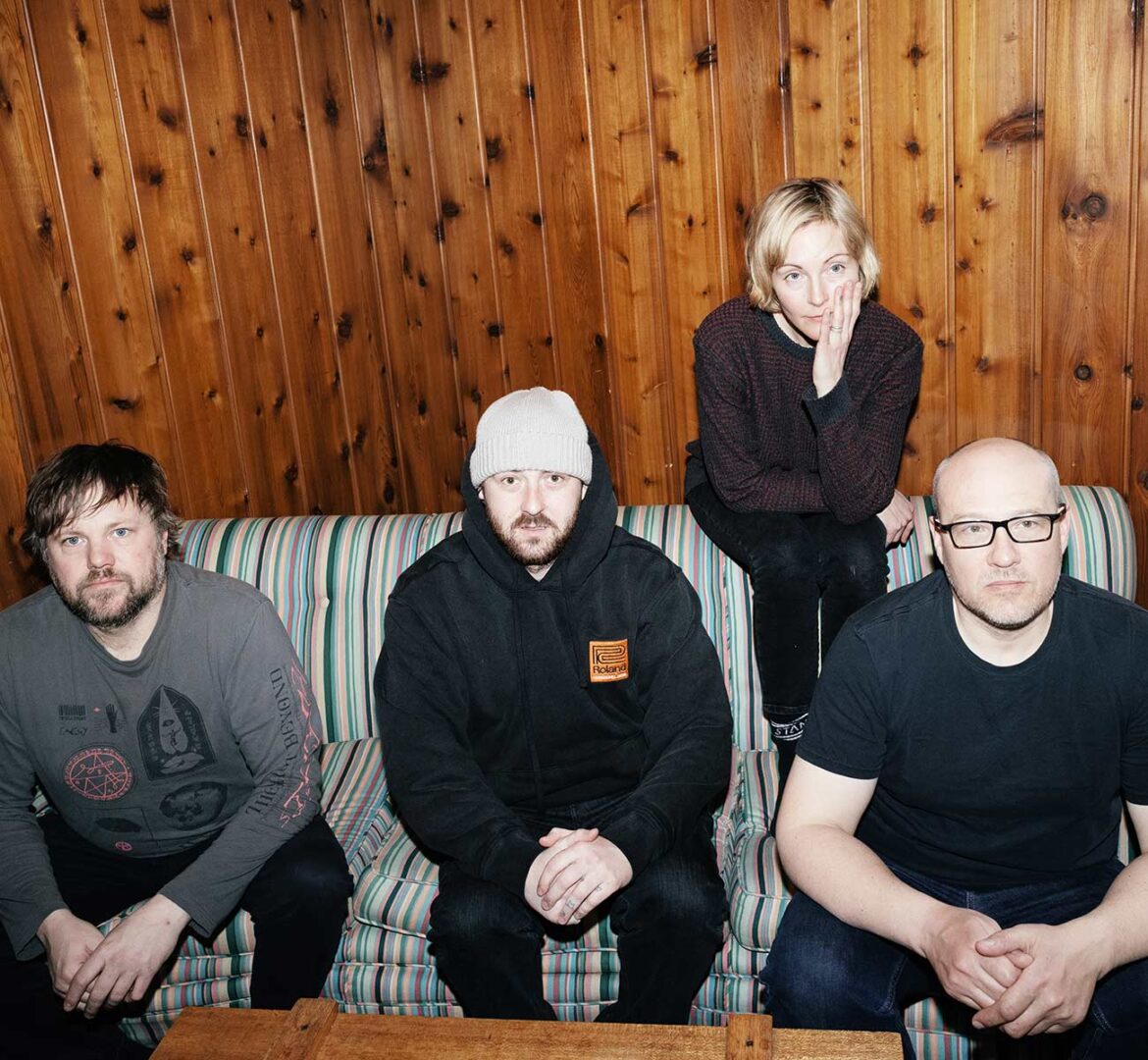 The Gully Boys band with three male artist sitting on a couch and female artist sitting on the back of the couch.