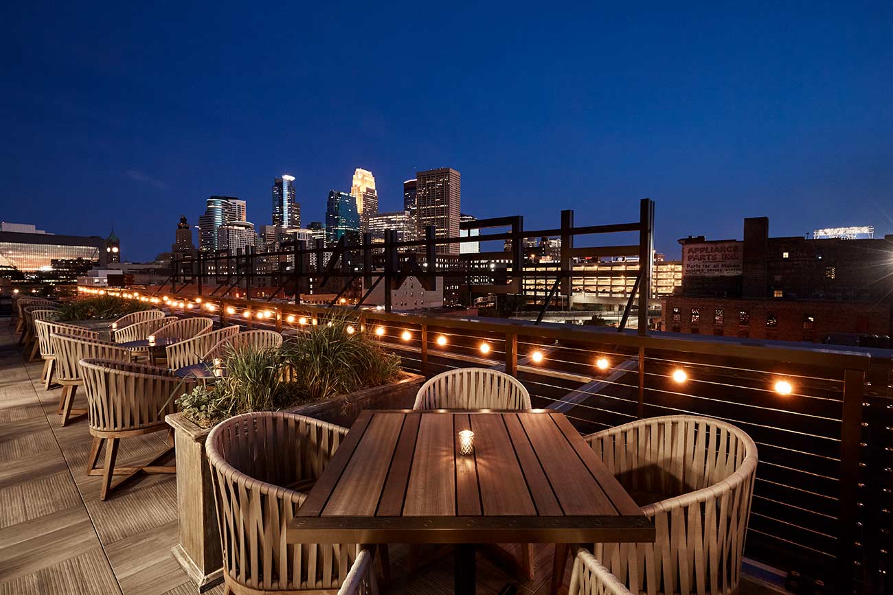 Hewing rooftop at night with the skyline of downtown Minneapolis.