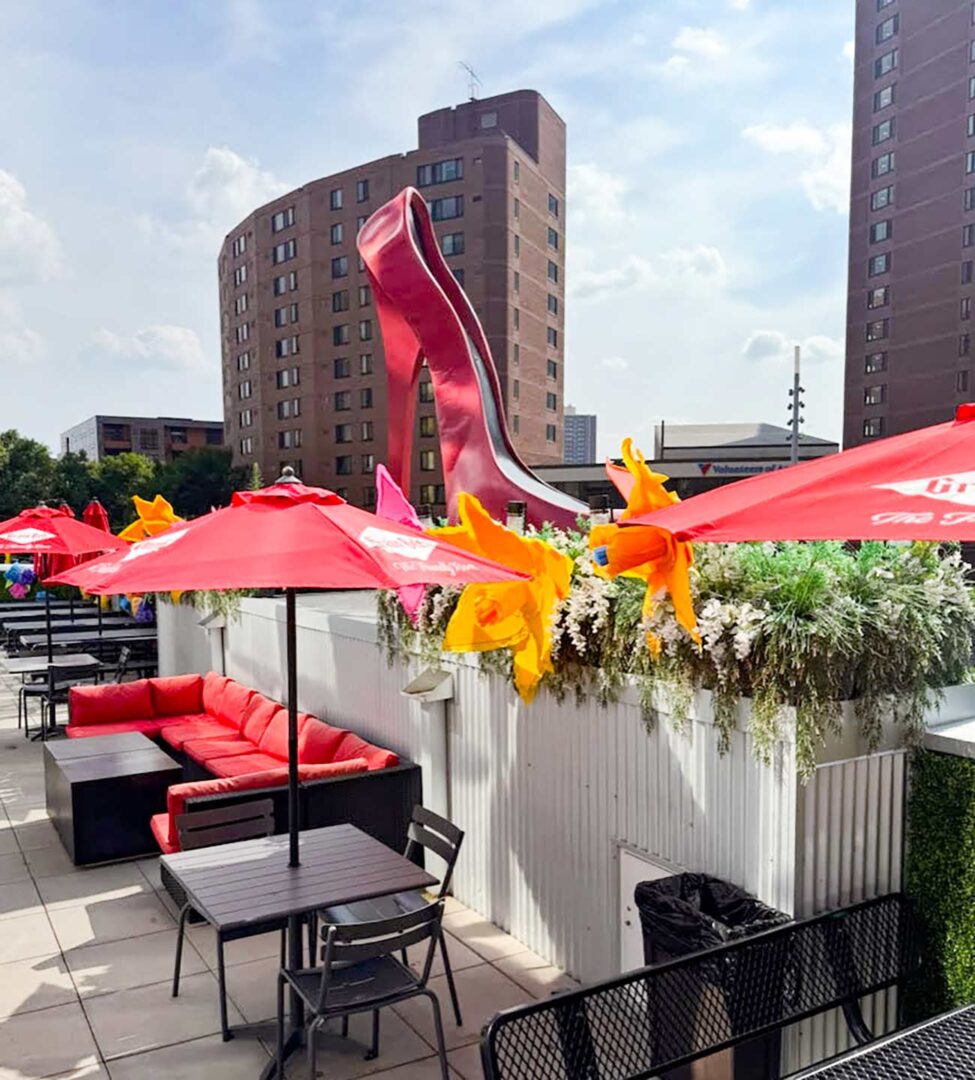 On the Rox rooftop with the giant red heel logo in the background.