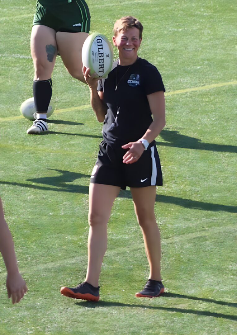 Twin Cities Gemini head couch Sylvia Braaten holding the ball on the field.