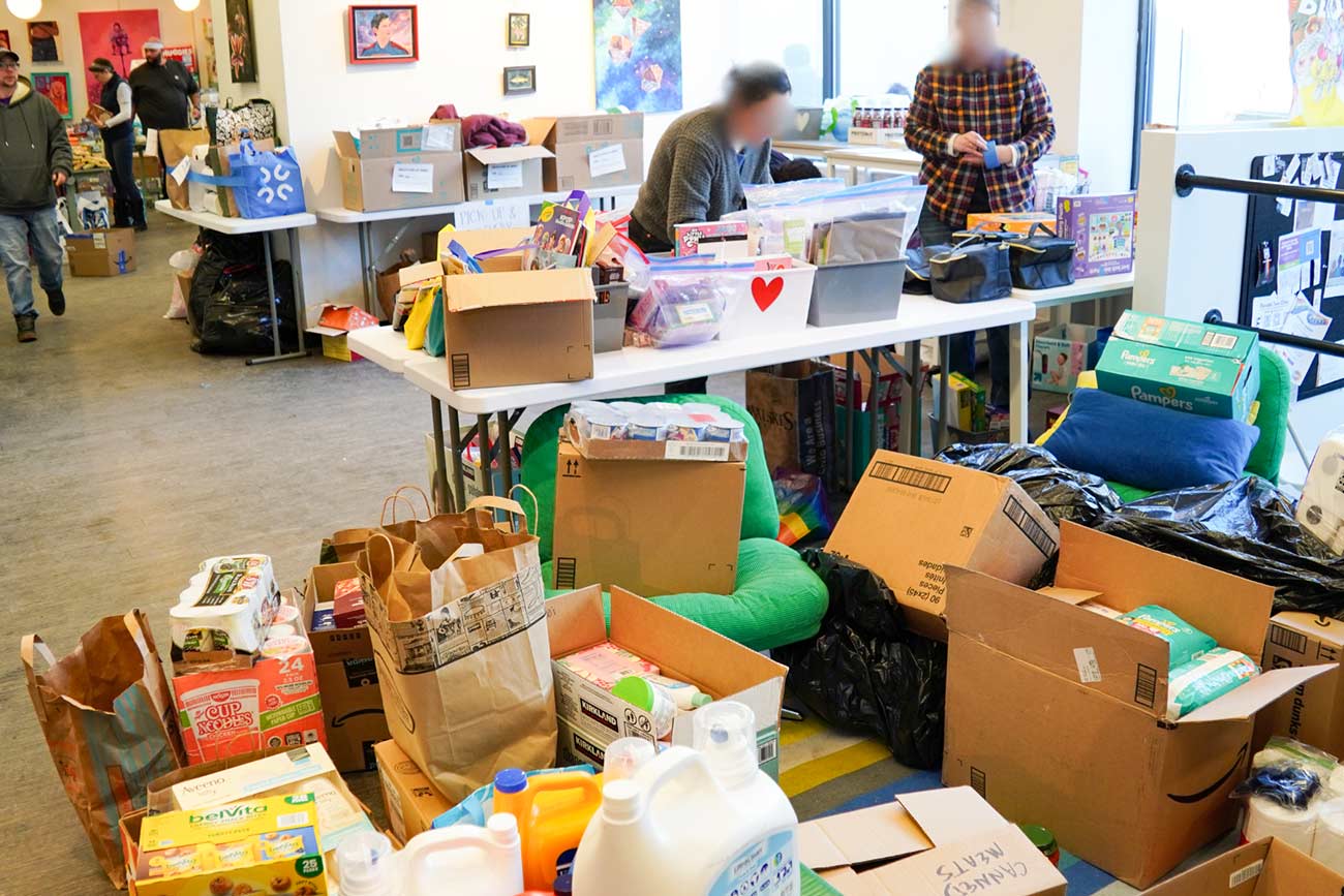 Volunteers sorting through donations to stock tables.