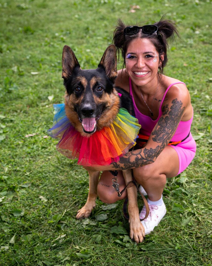 Woman smiling with her dog wearing a rainbow collar at Twin Cities Pride.